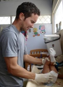 David changing a baby's diaper.