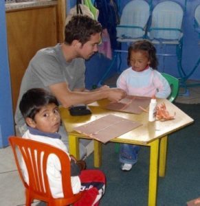 Younger David interacts with children at a small table.
