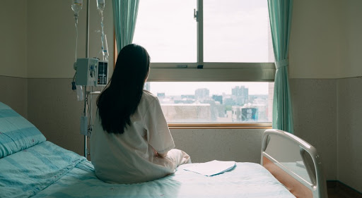 female patient sitting on a hospital bed looking out the window