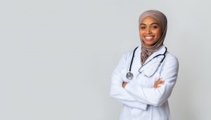 Portrait Of Smiling Black Female Doctor In Hijab And White Coat