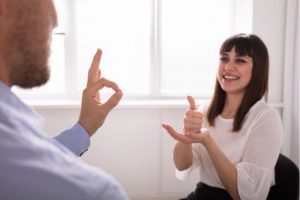 man and woman using american sign language