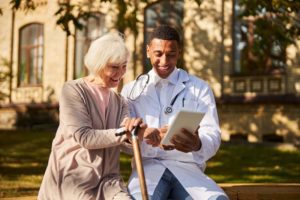 smiling older woman talking to doctor outside