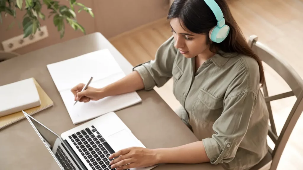 woman sitting down with headphones using video remote interpretation