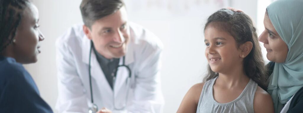 a woman wearing a hijab with young daughter on her lap, speaking to a doctor and an interpreter, showing how interpreters and translators provide equal access to care